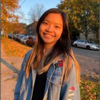 a person in a jean jacket smiling in the sunshine