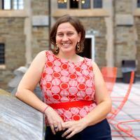 a woman smiling next to a building