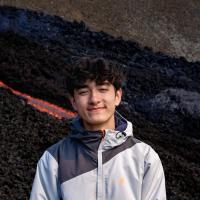 a person standing in front of a lava field smiling