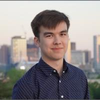 a person wearing a blue button down shirt against a city skyline