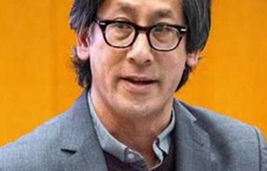 a person wearing glasses and a blazer