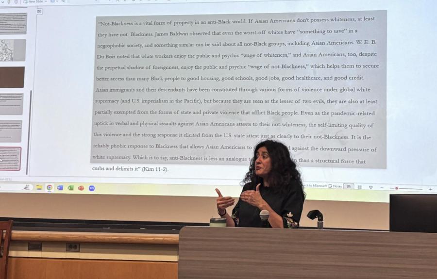 a person speaking in front of a screen with a quote