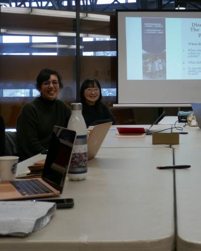 six people smiling at the camera and sitting around a table