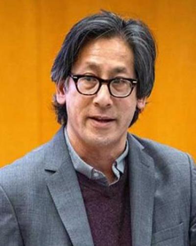 a person wearing glasses and a blazer